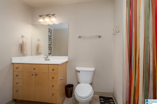 bathroom with vanity, toilet, and baseboards