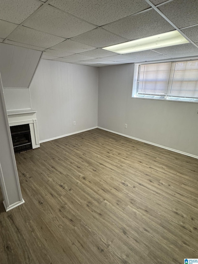 interior space featuring a drop ceiling and wood-type flooring