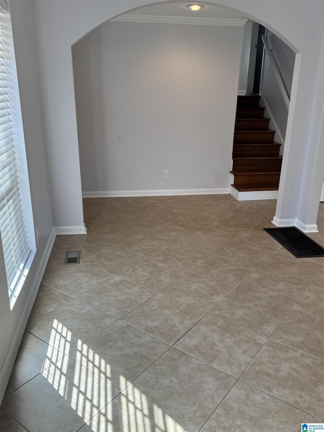 unfurnished living room with ornamental molding and light tile patterned flooring