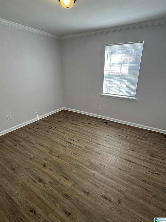 spare room with crown molding and dark wood-type flooring