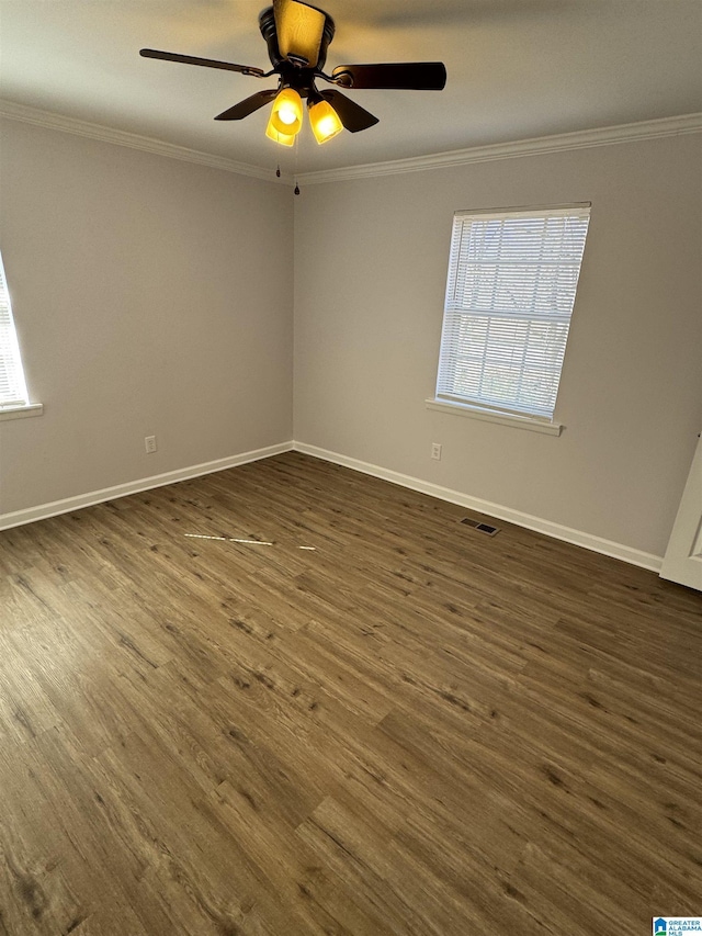 empty room with crown molding, dark wood-type flooring, and ceiling fan