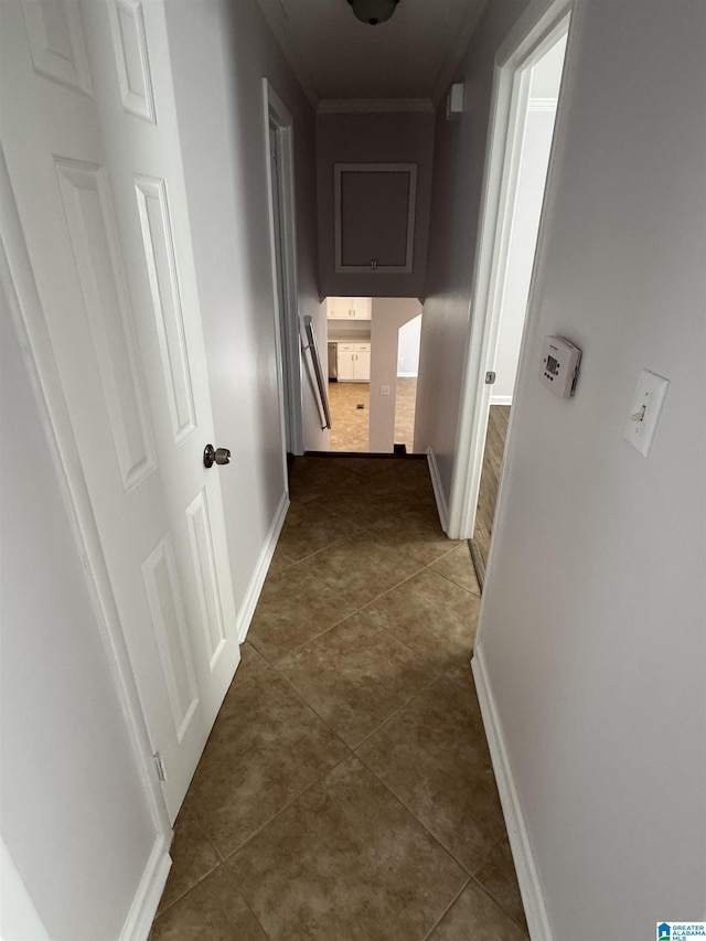 corridor with tile patterned flooring and crown molding