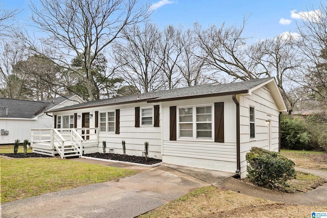 ranch-style house featuring a shingled roof, a front yard, and a deck