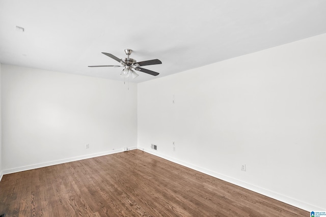 spare room with ceiling fan, visible vents, baseboards, and wood finished floors