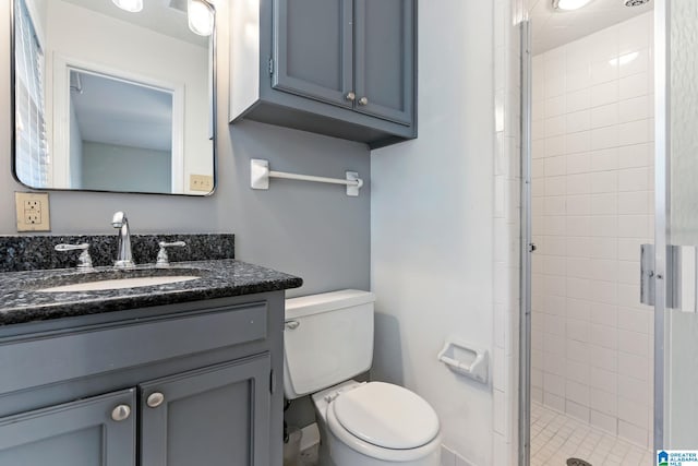 bathroom featuring toilet, a stall shower, and vanity