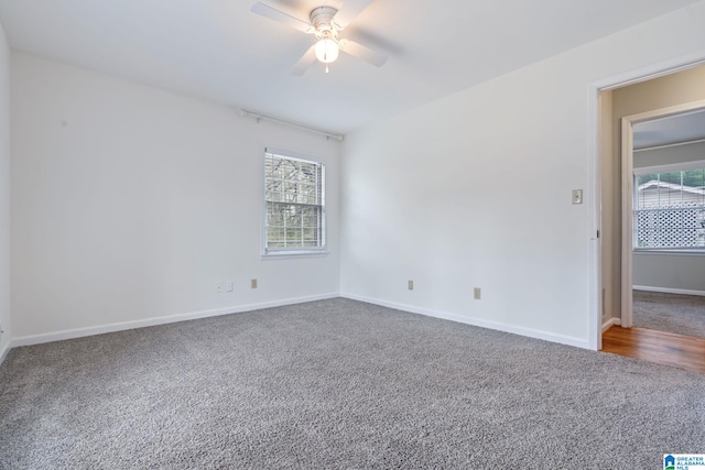 empty room with baseboards, carpet floors, a wealth of natural light, and a ceiling fan