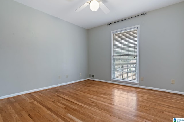 unfurnished room with light wood finished floors, ceiling fan, visible vents, and baseboards