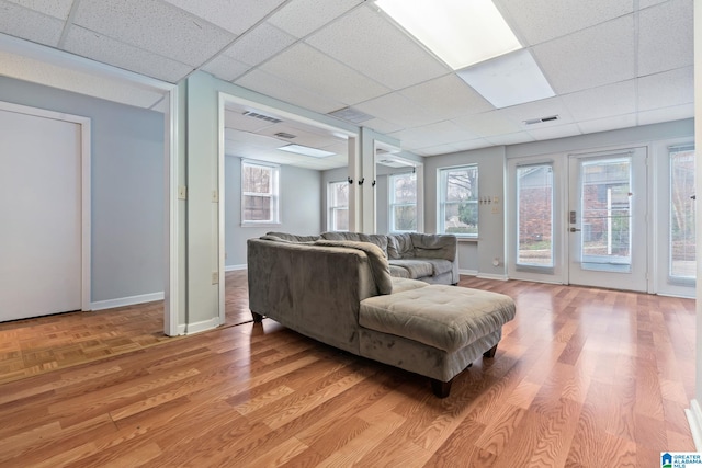 living area with baseboards, visible vents, and light wood-style floors