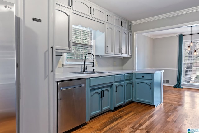 kitchen featuring appliances with stainless steel finishes, light countertops, blue cabinets, and a sink