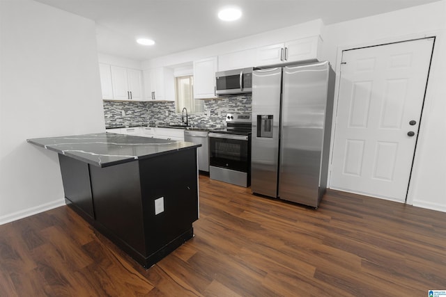 kitchen with white cabinetry, appliances with stainless steel finishes, dark hardwood / wood-style flooring, and kitchen peninsula