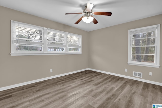 empty room with hardwood / wood-style floors and ceiling fan