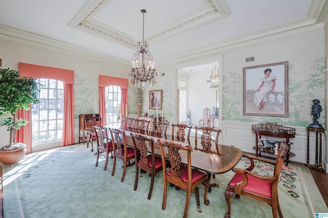 dining area with crown molding, hardwood / wood-style floors, a chandelier, and a tray ceiling