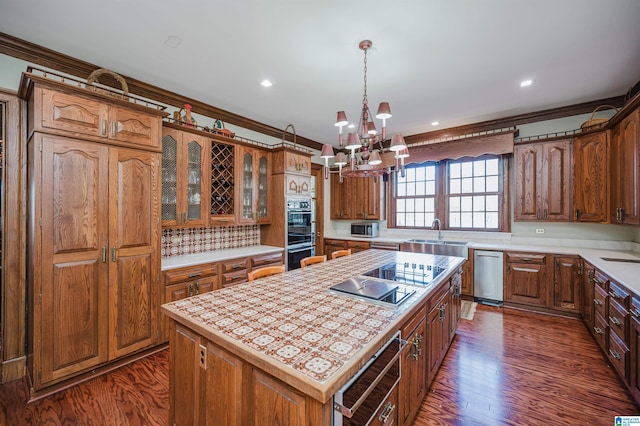 kitchen featuring crown molding, a center island, dark hardwood / wood-style floors, and black appliances