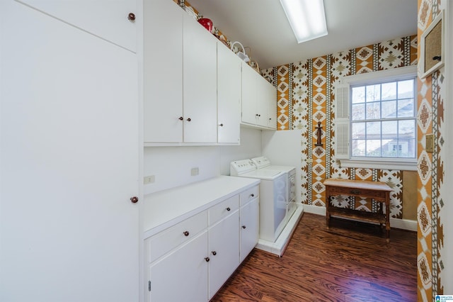 clothes washing area with cabinets, dark hardwood / wood-style floors, and washer and clothes dryer