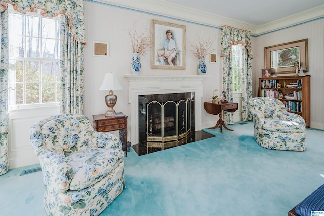 sitting room featuring ornamental molding, a premium fireplace, and carpet