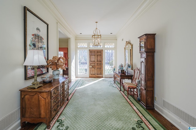 interior space featuring ornamental molding, dark wood-type flooring, and an inviting chandelier