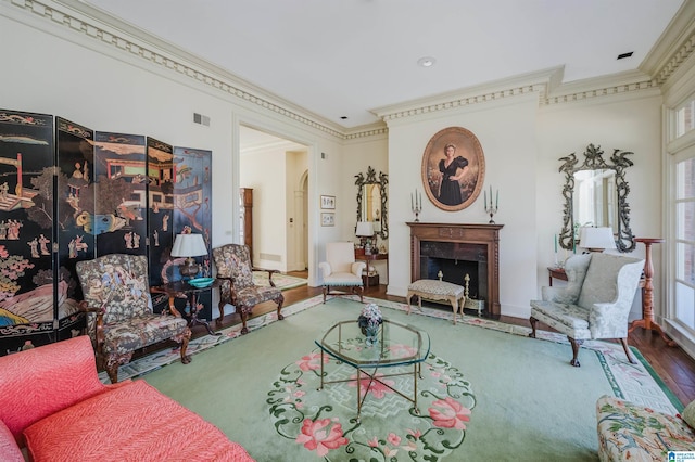 living area with crown molding, wood-type flooring, and a high end fireplace