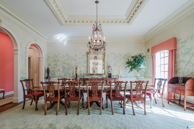 carpeted dining area with ornamental molding, a raised ceiling, and a notable chandelier