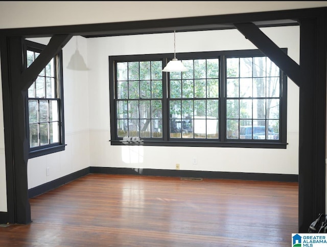 unfurnished dining area featuring dark hardwood / wood-style flooring