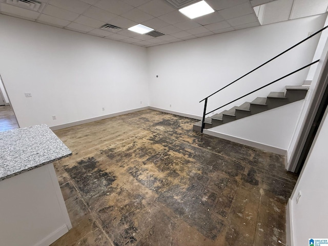 basement with dark hardwood / wood-style flooring and a drop ceiling