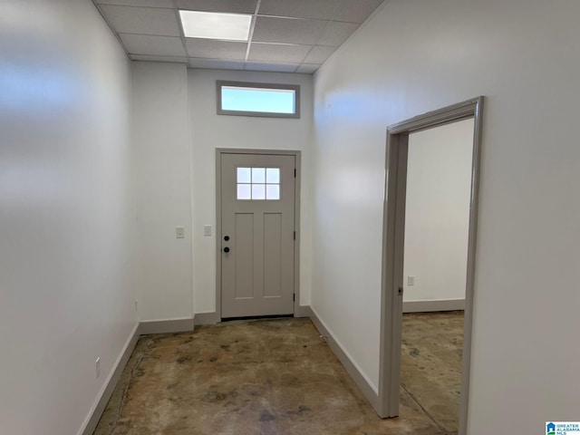 foyer with concrete flooring and a paneled ceiling