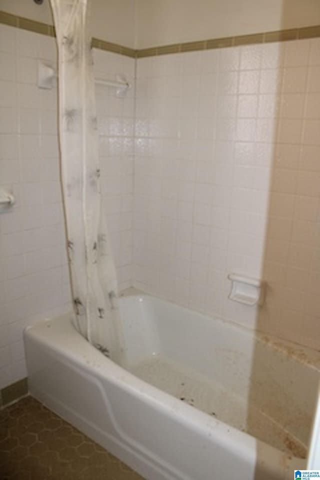 bathroom with tile patterned floors, shower / tub combo, and tile walls