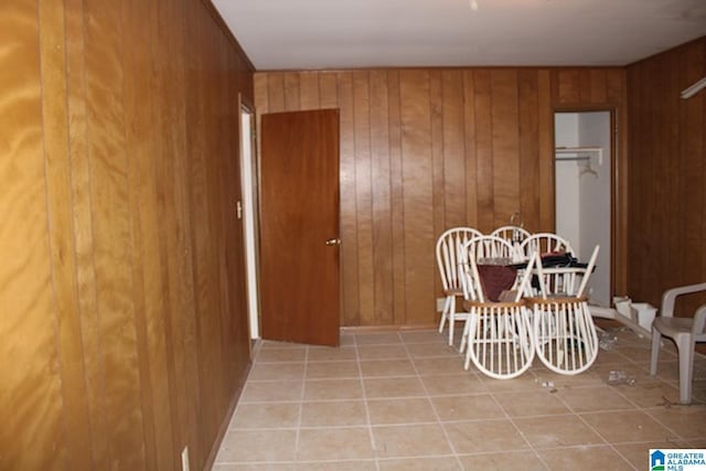 dining area with light tile patterned floors and wood walls