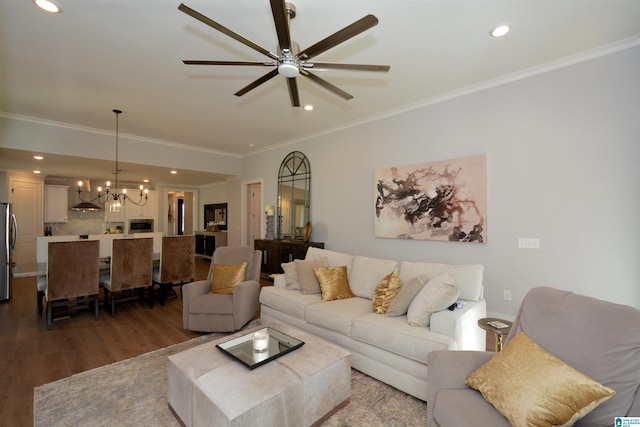 living room with ceiling fan with notable chandelier, ornamental molding, wood finished floors, and recessed lighting