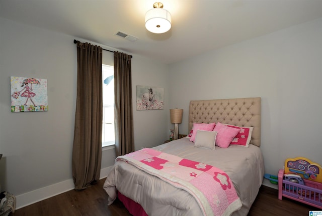 bedroom with dark wood-style floors, visible vents, and baseboards