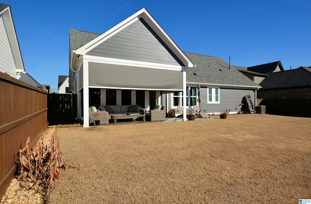 rear view of house with a fenced backyard, a patio, an outdoor living space, and roof with shingles