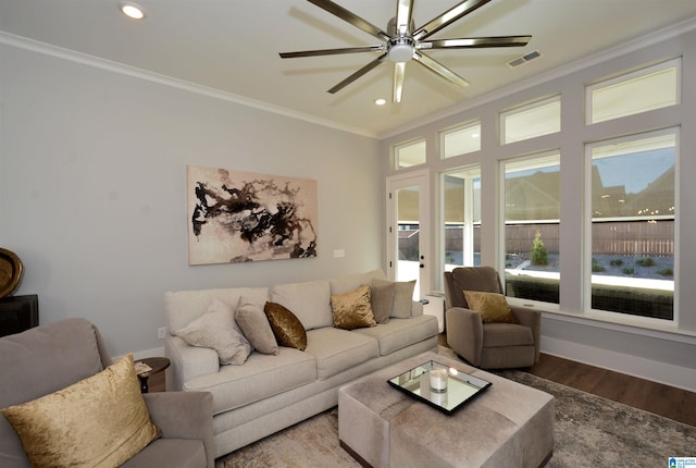 living area featuring visible vents, crown molding, baseboards, and wood finished floors