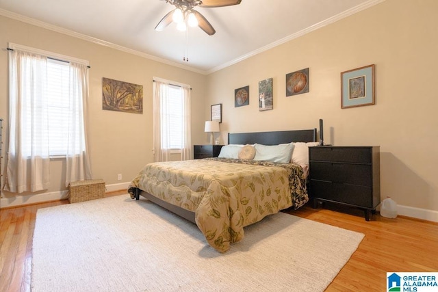 bedroom featuring hardwood / wood-style flooring, crown molding, and ceiling fan