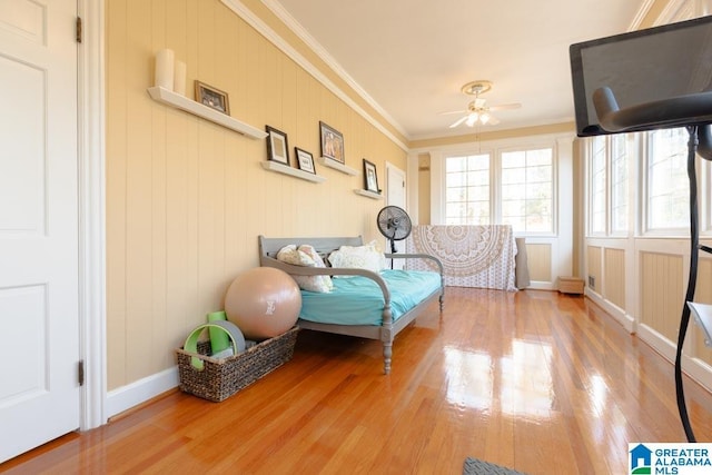 bedroom featuring ceiling fan, wood-type flooring, and ornamental molding