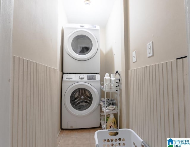 washroom featuring light tile patterned floors and stacked washer / drying machine