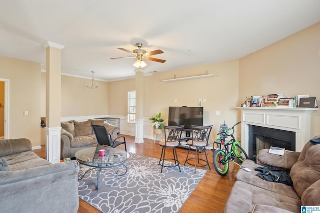 living room featuring ceiling fan, ornate columns, and wood-type flooring