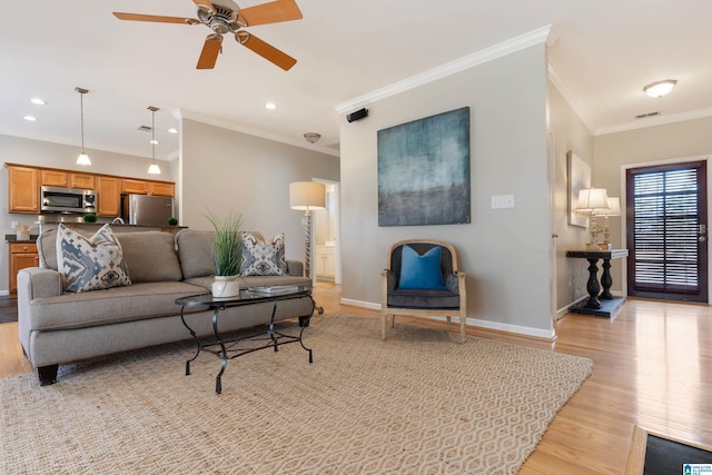 living room featuring light wood-type flooring, ornamental molding, and ceiling fan