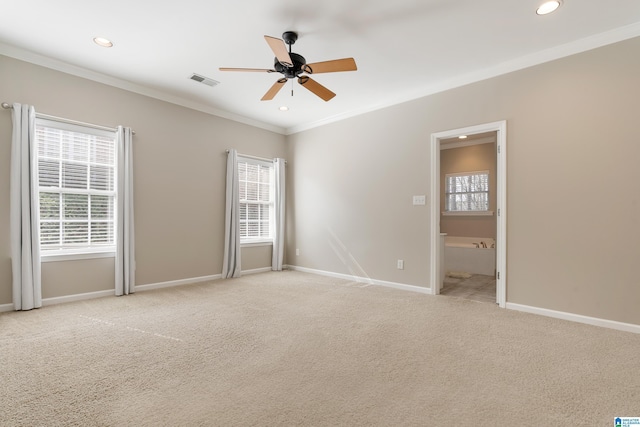 empty room with ceiling fan, light carpet, crown molding, and a healthy amount of sunlight