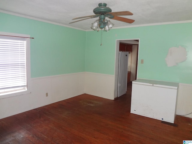 empty room featuring ceiling fan, ornamental molding, and dark hardwood / wood-style flooring