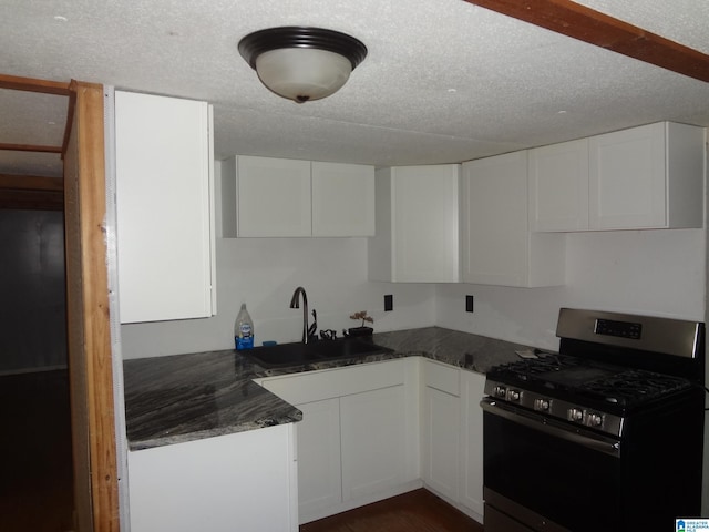 kitchen featuring sink, white cabinets, a textured ceiling, and stainless steel gas range