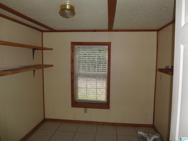 tiled spare room featuring a textured ceiling