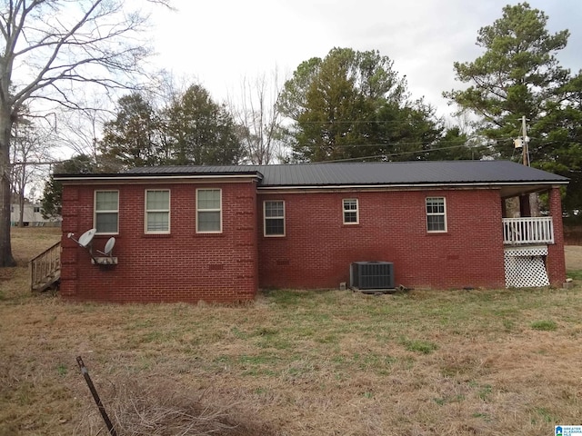 rear view of property with a lawn and central AC unit