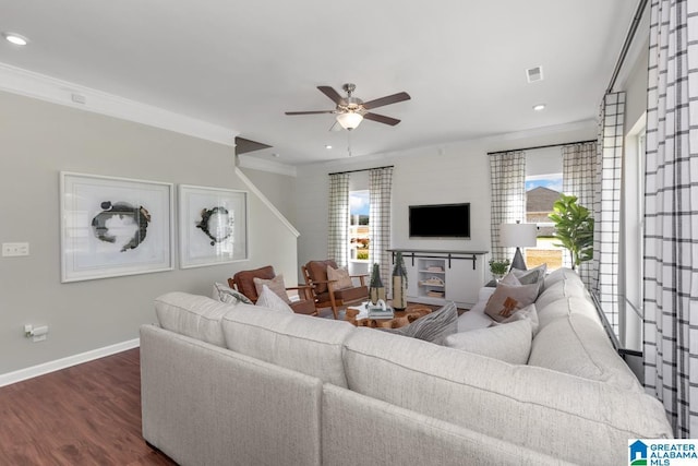 living room featuring dark wood-type flooring, crown molding, and ceiling fan