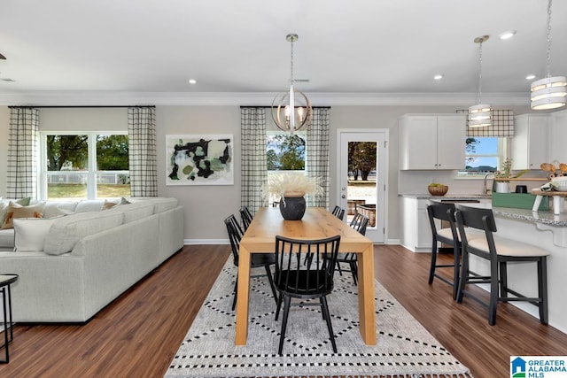 dining space featuring ornamental molding, dark wood-type flooring, and sink