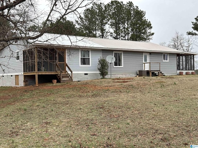 back of house featuring central AC, a sunroom, and a yard