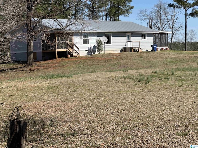 back of property with a yard, central air condition unit, and a sunroom