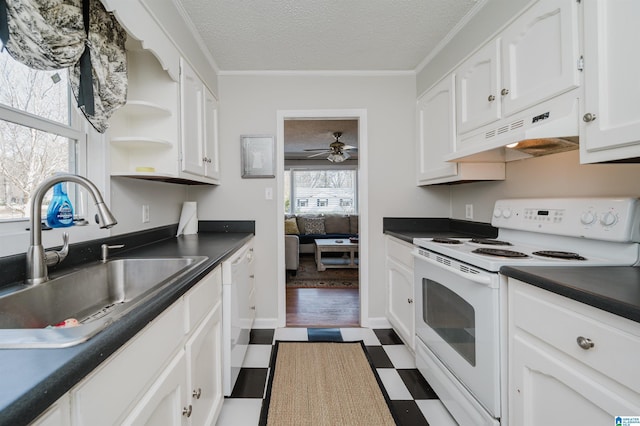 kitchen with dark countertops, white cabinetry, a sink, white appliances, and under cabinet range hood