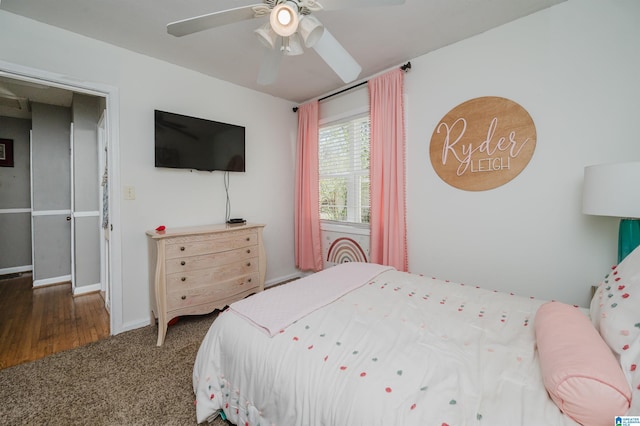 bedroom featuring dark carpet, baseboards, and ceiling fan