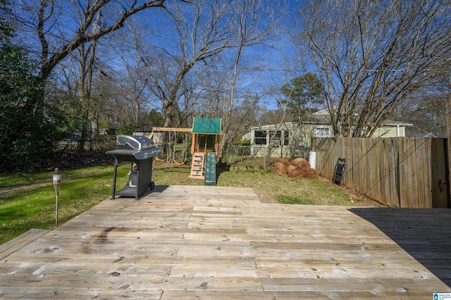 deck with a playground, fence, and area for grilling