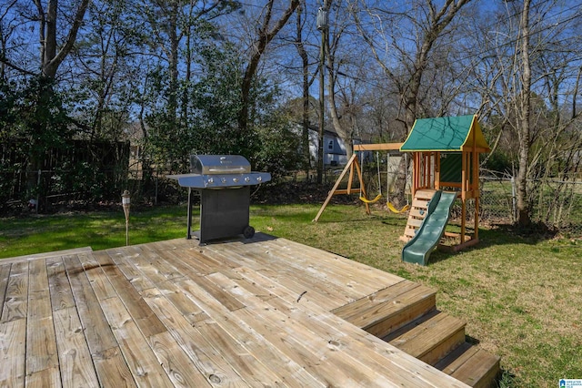 wooden deck featuring a yard, fence, a playground, and area for grilling