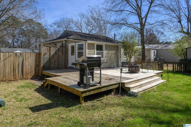 deck featuring an outbuilding, a yard, a grill, a fenced backyard, and a fire pit